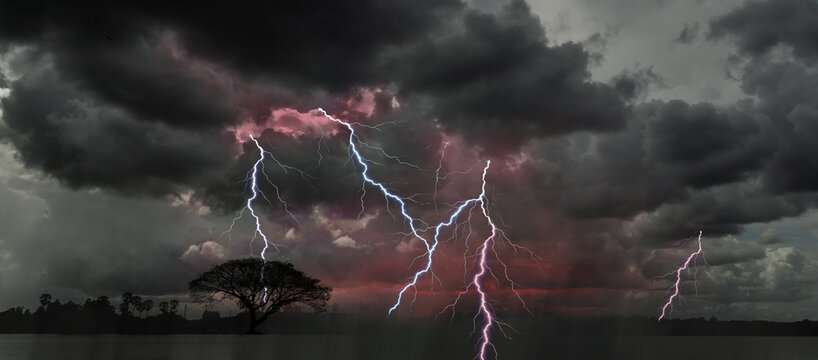 Lightning bolts illuminate the stormy night sky, approaching the viewer. terrifying Cloudy, Clodus of rain, balck color of clouds, Rainy strom.