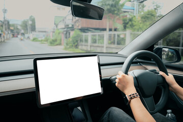 Person driving an electric car with a blank dashboard touchscreen in a modern vehicle interior