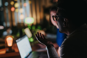 Colleagues work together on a project at night, brainstorming ideas and analyzing data. The...