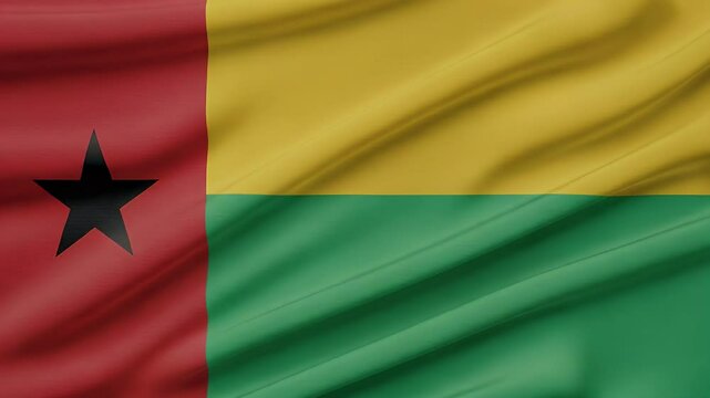 Close-up view of the Guinea bissau national flag waving in the wind, with its bold red, yellow, and green stripes and the black star in the red section. Represents national pride and independence.
