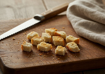 A worn cutting board with fresh bread crumbs