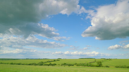 A serene and peaceful landscape featuring a bright blue sky and lush green fields all around