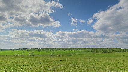 A Beautiful and Scenic Green Landscape with a Stunning and Dramatic Cloudy Sky Above It Time lapse.