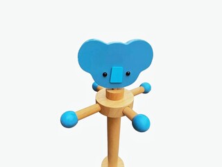 The white background in the picture is a decorative wooden object used for hanging things made of brown wood decorated with a face pattern and a blue button with black eyes and blue dots used for hang