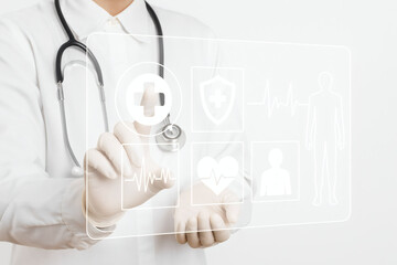 A doctor touches a digital medical panel with icons like a plus sign and heart.