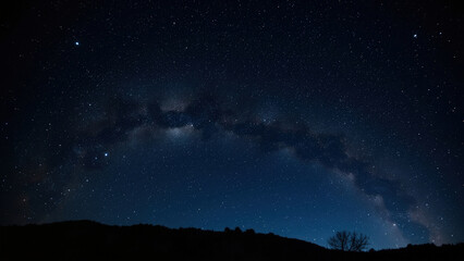 Night sky landscape silhouette with visible Milky Way galaxy and stars above a dark mountain range and tree