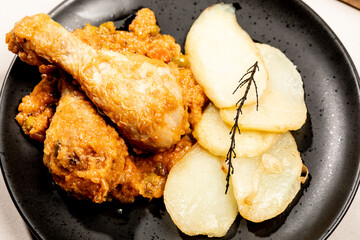 Close up of baked chicken with vegetable sauce and potatoes