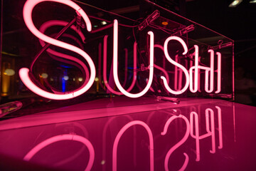 Glowing Neon Sushi Sign with Pink Reflection