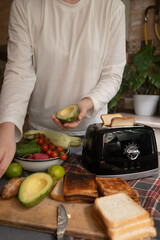 Young woman puts slices of bread into toaster for quick and tasty breakfast easy morning routine...