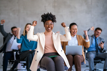 Happy businesspeople laughing while collaborating on a new project in an office.