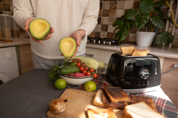 Girl turns on toaster pressing lever down bread slices slowly lower from top view kitchen scene.