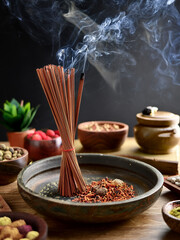 Spiritual imagery of incense burning with rising smoke and earthy tones in a tranquil setting.