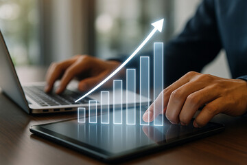Business growth strategy using laptop and tablet with financial chart and arrow going up concept