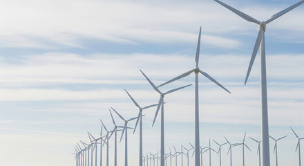 Wind turbines on open field under cloudy sky