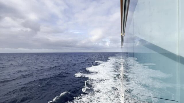 Transpacific cruise: calm ocean wake seen from ship balcony on overcast day deep blue Pacific from Alaska to Hawaii