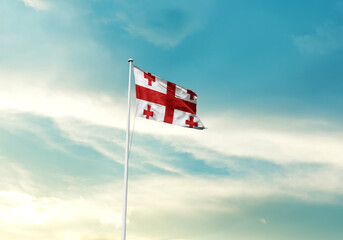 Georgia flag is waving on a tall flagpole among the clouds. Georgia national flag for independence day.