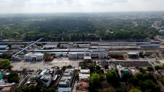 Rail lines with colorful trains and station sheds under bright daylight
