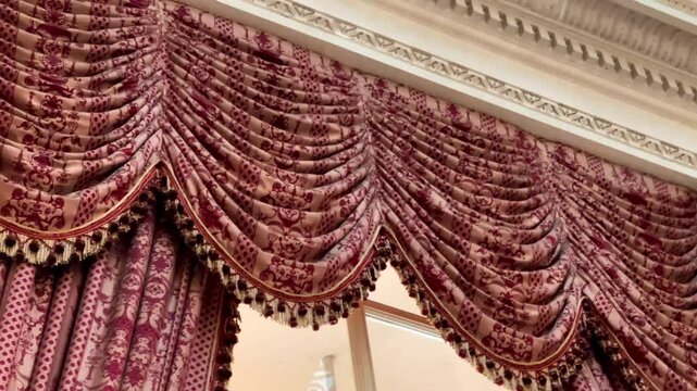 Traditional English interior cornice with deep red damask swags and detailed plasterwork, evoking a refined heritage drawing room, slow motion