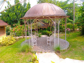 A minimalist garden gazebo featuring a sleek metal frame and domed roof, blending modern...