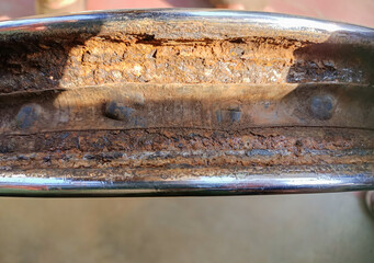 A Close up view of a Motorcycle wheel rim seen rusted, withered, damaged, worn out and unfit for...