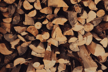 Stacked firewood background with textured logs. Cut firewood front view.