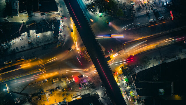 Top down Aerial view of cross traffic highway with cars, trucks aerial. Urban transportation at bridge road at Delhi. Cinematic cityscape of downtown freeway drone shot. Noida Freeway.