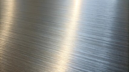 The brushed silver metal texture catches the light, creating a sleek and modern abstract background