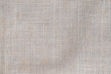 Hessian sackcloth woven jute burlap hemp fabric cloth textile texture pattern background in sepia brown beige aged color