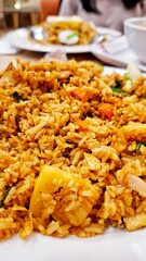 Traditional fried rice with authentic Indonesian spices served on a white plate. A mix of tropical spices and vegetables.