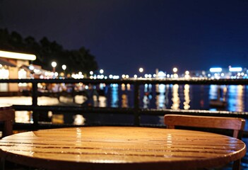 Portrait of an empty table in a harborside cafe after rain at night
