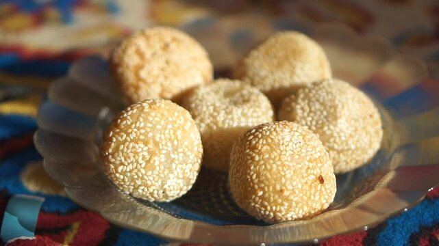 Onde-onde or traditional sesame balls filled with sweet mung bean paste, a popular Asian snack served on a decorative plate.