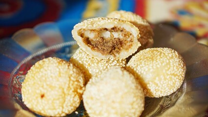 Onde-onde or traditional sesame balls filled with sweet mung bean paste, a popular Asian snack served on a decorative plate.