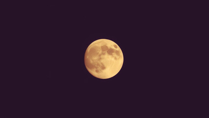 Fototapeta premium Bright full moon illuminates the night sky showcasing its detailed surface features and glowing appearance