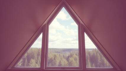 Beautiful triangular window view of forest landscape under a cloudy sky in a tranquil setting