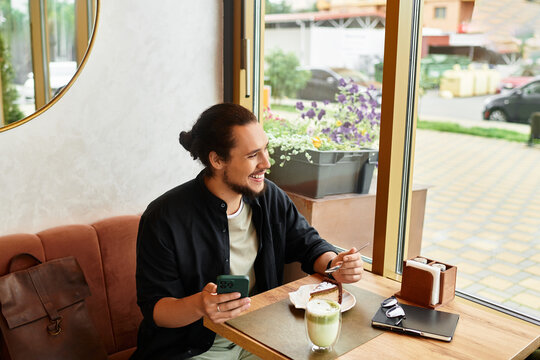 Young man enjoys remote work while savoring matcha and cake in a cafe