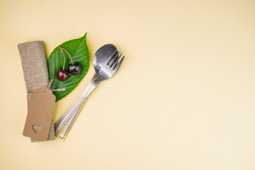 Eco-friendly table setting with kraft paper, cherries and silverware