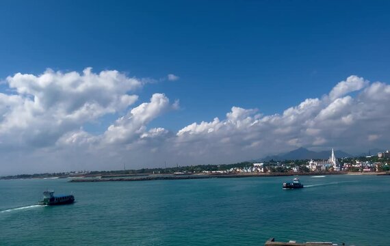 A boat and ship travel across scenic coastal waters peacefully
