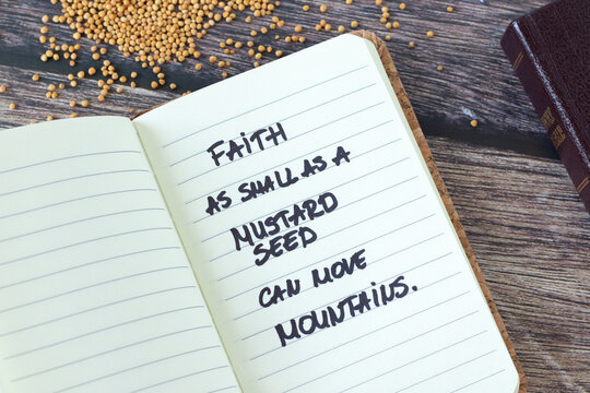 Faith as mustard seed can move mountains, inspirational handwritten quote in notebook with holy bible book on wooden table. Trust and belief in God Jesus Christ, biblical concept.