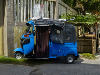 Rickshaw car for transporting people. Motor rickshaw, auto rickshaw, tuk-tuk, mototaxi. Three-wheeled motor scooter.