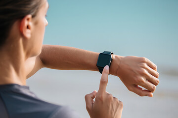 Woman Uses Smartwatch on Beach Fitness and Healthy Lifestyle