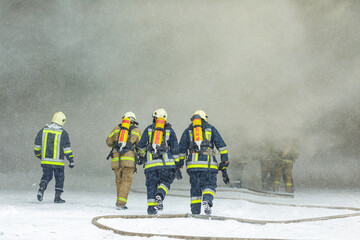Firefighters Entering Burning Building During Emergency Rescue Operation Surrounded by Dense Smoke
