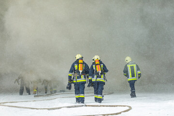 Firefighters in Action Entering Smoky Scene During Emergency Rescue Operation in Winter Conditions