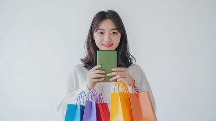 Young energetic Asian woman holding blank use smartphone searching shop retail with colorful shopping bags on white background. Online shoping futuristic concept.
