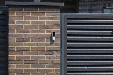 A sleek intercom device is installed on a stylish brick wall, facilitating secure communication at...