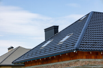 Rooftops made of stylish tiles catch the sunlight, with a sleek chimney rising against the backdrop...