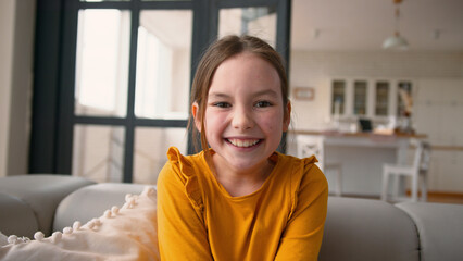 Carefree joyful Caucasian schoolgirl portrait rejoice looking at camera at home mortgage custody...