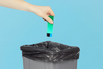 throw the lighter in the trash, outstretched hand with a lighter in front of the trash can, the concept of the dangers of smoking cigarettes, quitting smoking