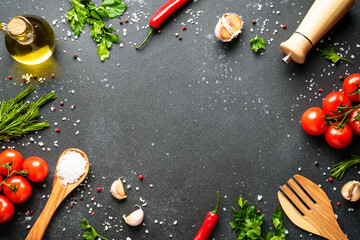 Food background with fresh vegetables, herbs and spices on black.