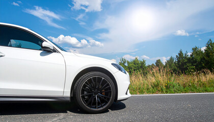 Fototapeta premium White Sport Car Parked on the Road Against a Bright Sunny Sky Perfect for Automotive Design Luxury Vehicle Concepts and Outdoor Lifestyle Imagery