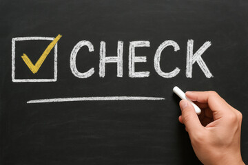 黒板にチェックマークと文字を書く手元のビジネスコンセプト